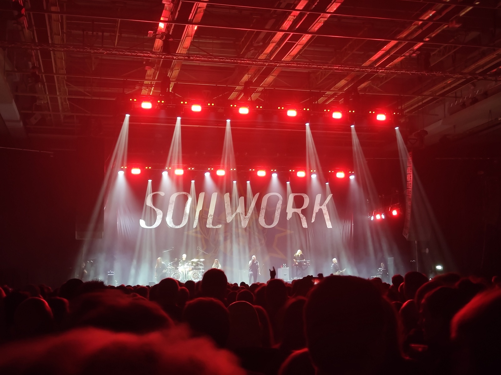 The Soilwork text logo written across the stage backdrop, photographed from afar